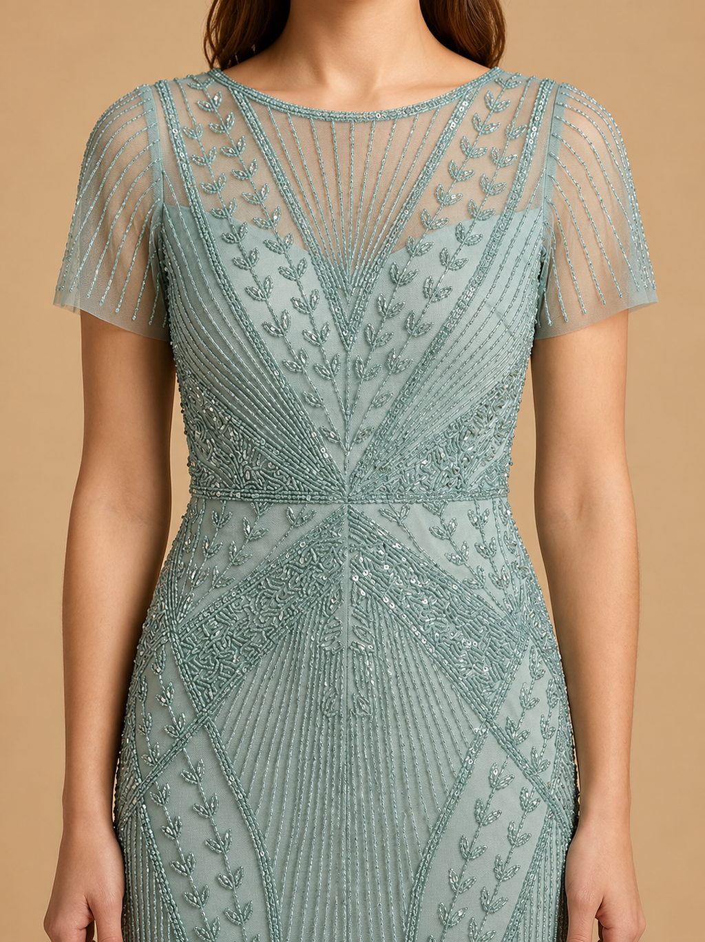 A woman wearing a fitted, short-sleeve evening gown with intricate bead and sequin detailing in a dusty sage green color, set against a solid beige background.