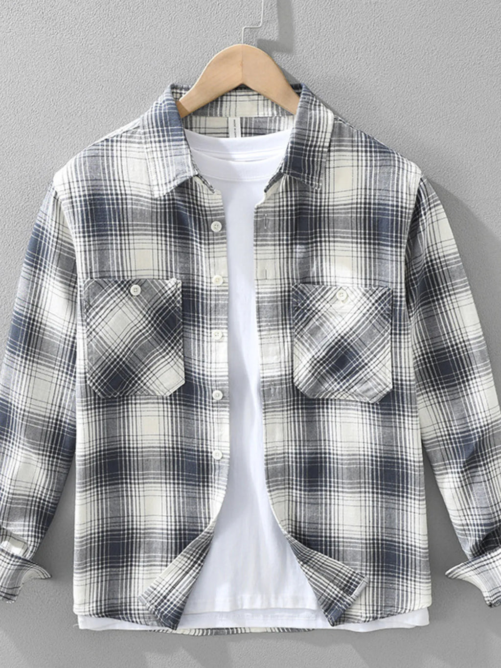 Plaid shirt on a hanger against a gray background