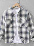Plaid shirt on a hanger against a gray background